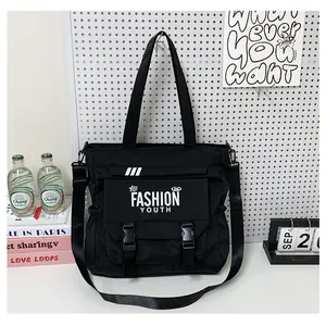 Détail du sac cabas en toile noire avec poches à boucle et bandoulière réglable