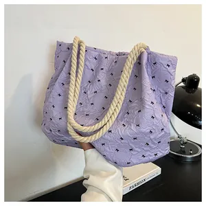 Detail of lavender tote bag with bow print and woven rope handle for daily commute
