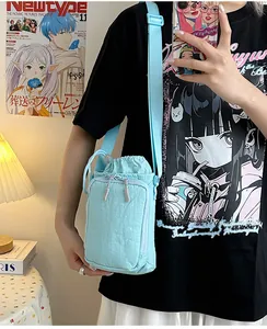 Detail van lichtblauwe nylon crossbodytas met trekkoord en verstelbare brede schouderriem