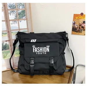 Détail du sac messager noir en toile avec boucles réglables et imprimé de mode moderne