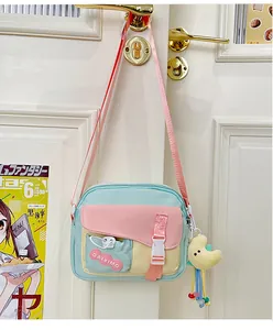 Dettaglio della borsa a tracolla in nylon multicolore con fibbia rosa e ciondolo a luna