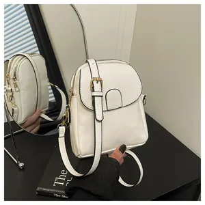 Detail of white PU leather mini crossbody bag with gold buckle and magnetic snap closure