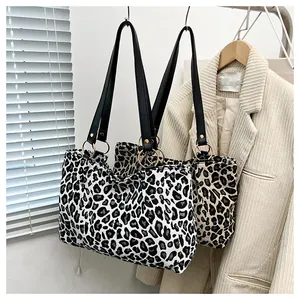 Macro shot of stylish zebra print tote bag with faux leather straps and metal ring details