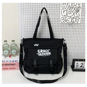 Détail du grand sac cabas utilitaire noir avec boucle de fermeture et sangle ajustable