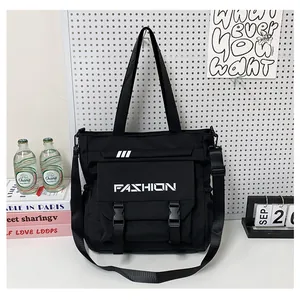 Détail du sac fourre-tout en toile noire avec double boucle et bandoulière