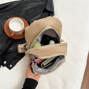 Minimalist cream nylon chest bag with multiple pockets showing daily storage capacity