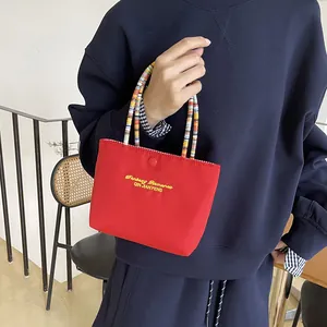 Cute red canvas handbag with embroidery and colorful beaded handle for daily travel