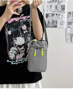 Graue Umhängetasche aus Nylon mit Kordelzug und neongelben Reißverschluss-Details