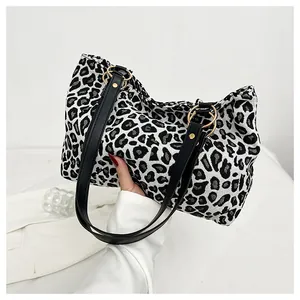 Detailed macro view of zebra pattern woven tote bag with black leather handle and gold rings