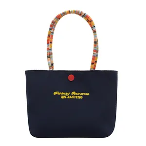 Dark blue nylon handbag with colorful woven handles and Fantasy Romance embroidery