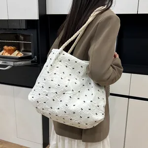 White large capacity tote bag with black bow patterns and woven rope handles