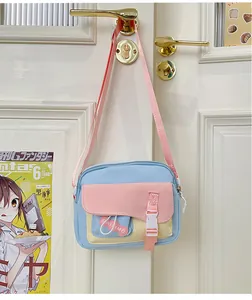 Dettaglio della borsa a tracolla in nylon rosa e blu con fibbia appesa a una maniglia