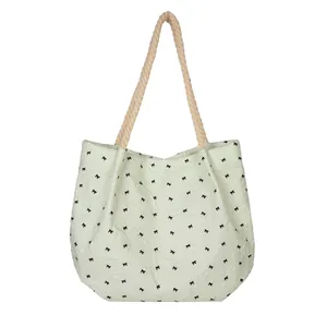 Light green pleated tote bag with black bow prints and cream braided rope handles