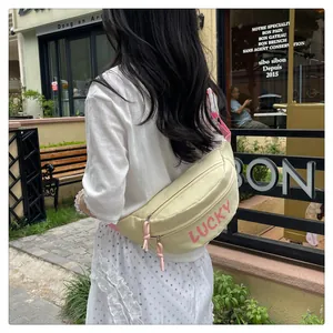 Detail der beige Umhängetasche mit rosa LUCKY-Aufdruck und dekorativer Kordel am Reißverschluss