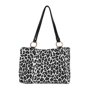 Fashionable zebra print canvas tote bag with black faux leather straps on white background