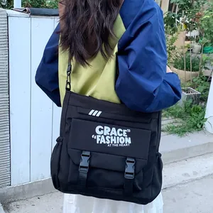 Grand sac messager noir pour étudiants avec fermoir à boucle et texte blanc imprimé