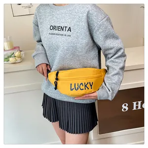 Detail der gelben Canvas-Gürteltasche mit Lucky-Aufdruck und blauem Kordelzug am Zipper