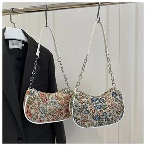 Detalle de bolsos de hombro jacquard floral con lazo plateado y correa de cadena metal