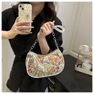 Detalle de bolso de hombro jacquard floral con lazo plateado y cadena