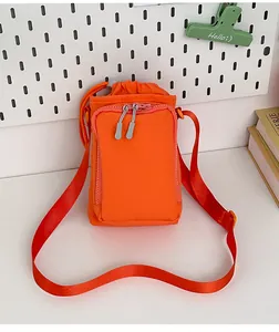 Detail einer hellorangen Nylon-Umhängetasche mit Kordelzug und Reißverschlussfach