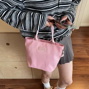 Pink nylon tote bag with Fashion label shown in a casual lifestyle setting