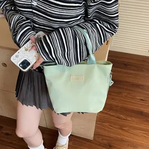 Light green minimalist casual tote bag with fashion tag and zipper closure for women