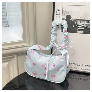 Close-up of light blue floral canvas bag with pink roses and ruffled handle design