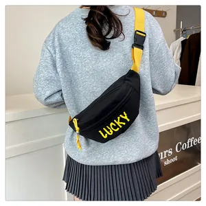 Detail der schwarzen Umhängetasche mit gelbem LUCKY Aufdruck und verstellbarem Gurtband