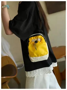 Primer plano de bolso bandolera con cordón amarillo y blanco y etiqueta Fashion