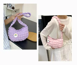 Détail du sac à bandoulière texture bulle avec patch nuage arc-en-ciel et fermeture éclair