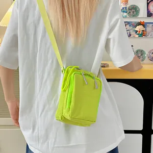 Neongrüne Nylon-Umhängetasche mit verstellbarem Riemen, getragen von einer Person