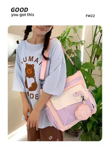 Détail du sac messager rose et violet avec écusson étoile et petit porte-monnaie assorti
