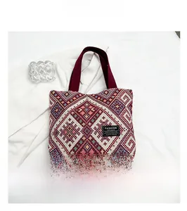 Macro detail of geometric ethnic knit tote bag with Fashion Instinct label and purple handle