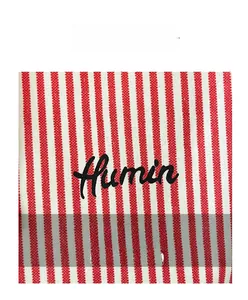 Detail of red and white striped canvas fabric with black Humin script embroidery