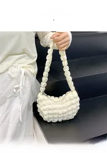 Détail du sac nuage crème avec texture à bulles porté par un mannequin de 165 cm de haut
