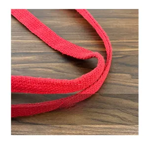 Detailed close-up of red woven canvas strap on the striped tote bag for durability