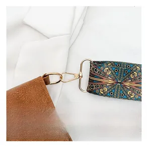 Detail of vintage brown leather tote bag featuring ethnic patterned wide shoulder strap