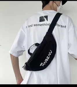 Close-up of black crossbody chest bag featuring adjustable strap and white letter print