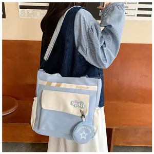 Détail du sac bandoulière contrasté bleu clair avec mini porte-monnaie étoile