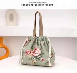 Vue détaillée du sac à main en toile à fleurs avec cordon et poignées tissées