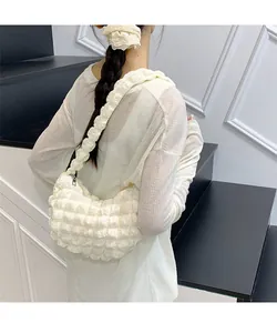 Détail de la texture bulles du sac à bandoulière froncé blanc cassé au style tendance