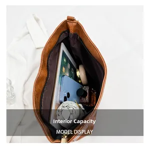 Internal capacity of the large brown leather tote bag showing items and zipper