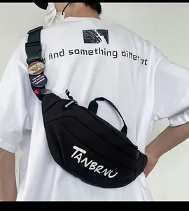 Close-up of black canvas chest bag with white art font and vintage shoulder strap badges