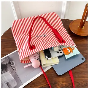 Spacious red striped canvas tote bag showing interior storage for tablet and umbrella