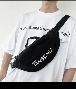 Detailed view of black canvas crossbody chest bag featuring white logo on male model
