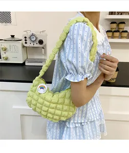 Détail du sac à bandoulière vert clair plissé à bulles avec un badge arc-en-ciel mignon