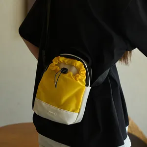 Mini bolso bandolera amarillo con cordón y etiqueta de moda llevado en un estilo casual