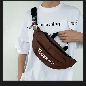 Detail view of the brown nylon crossbody chest bag showing adjustable strap and text logo