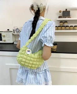 Détail du sac nuage vert clair avec texture bouffante et badge arc-en-ciel sur la bandoulière