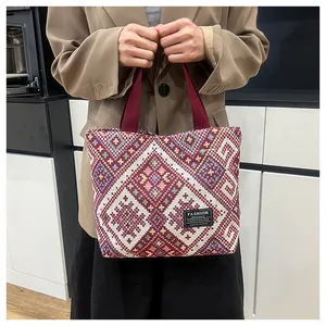 Close-up of ethnic woven tote bag featuring red geometric patterns and canvas handles